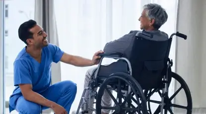 Caregiver gently holding the hand of a patient