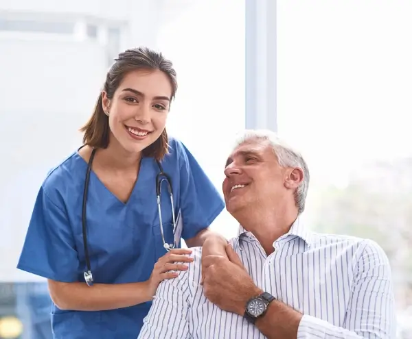 Caregiver helping two seniors with an activity at home
