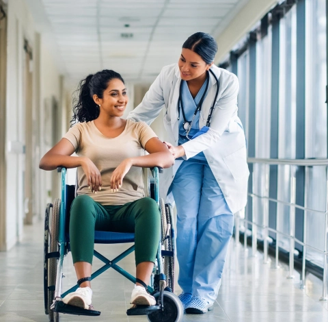 Caregiver helping an elderly patient in a wheelchair at home